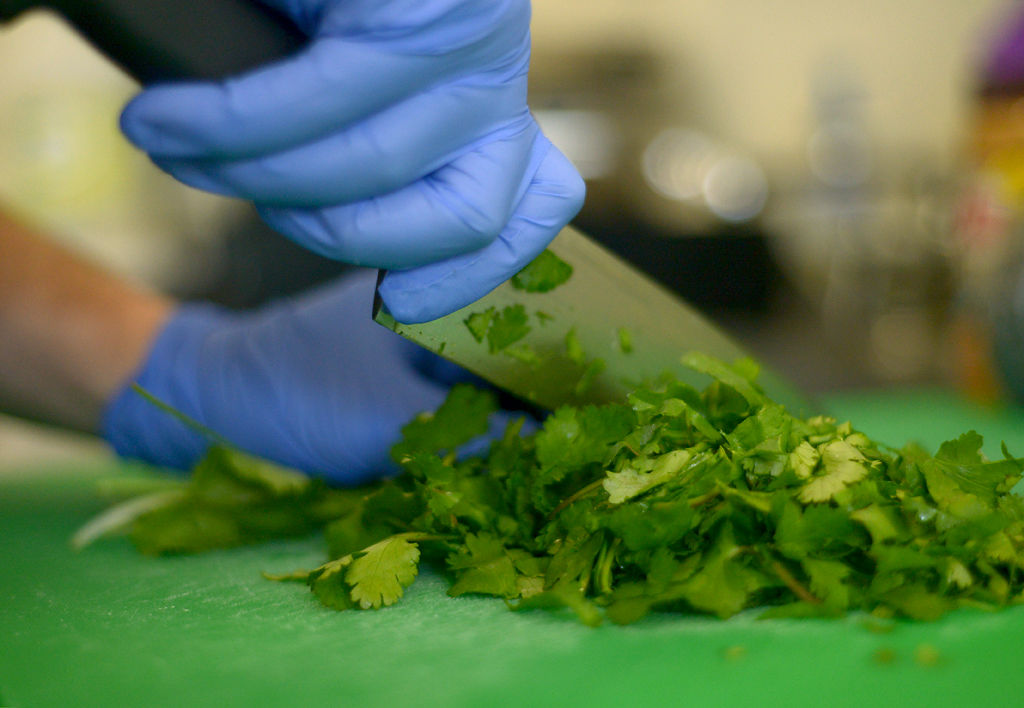 Colin Enslin chops up cilantro for to-go meals